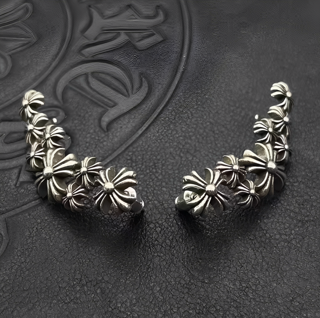 Pair of silver floral earrings on a textured dark background