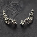 Pair of silver floral earrings on a textured dark background