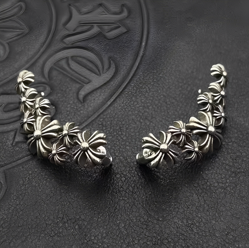 Pair of silver floral earrings on a textured dark background