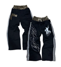 Two pairs of black pants with decorative elements on a patterned background