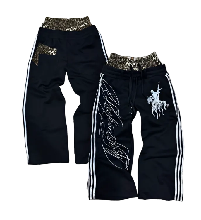 Two pairs of black pants with decorative elements on a patterned background
